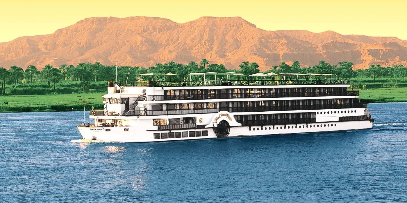 "Luxury Nile cruise sailing past the scenic riverbanks of Egypt at sunset