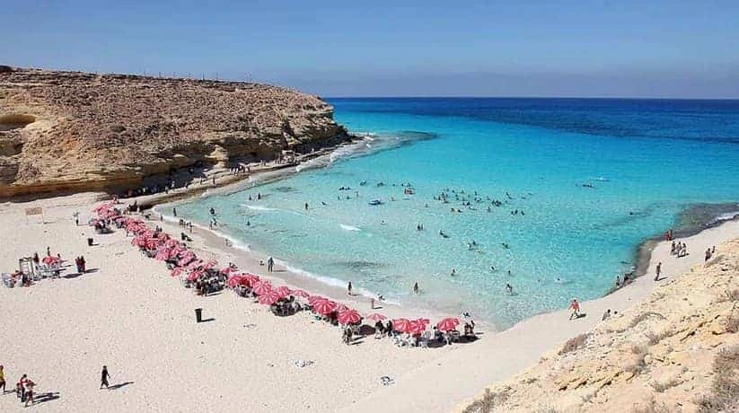 Agiba Beach in Marsa Matrouh, Egypt, featuring turquoise Mediterranean waters and dramatic rocky cliffs.